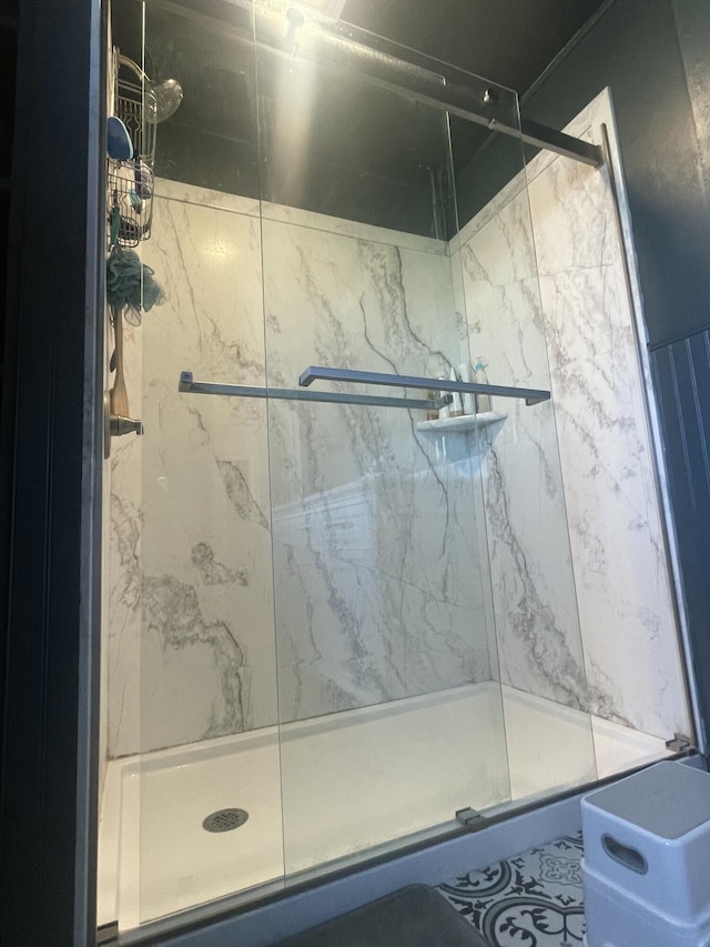 full bathroom with a marble finish shower