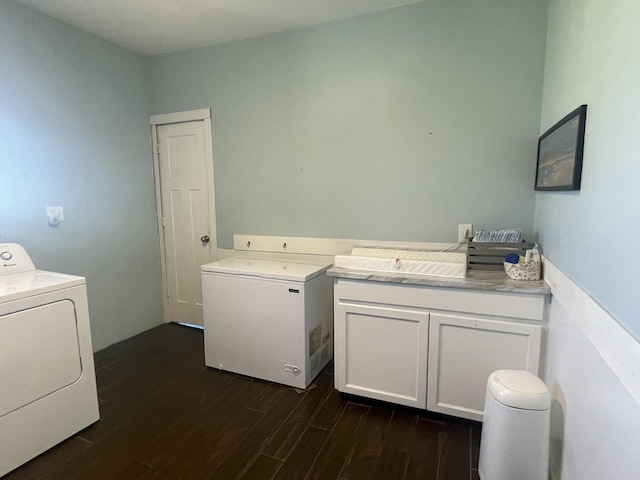 laundry room with dark wood finished floors, washer / dryer, and laundry area