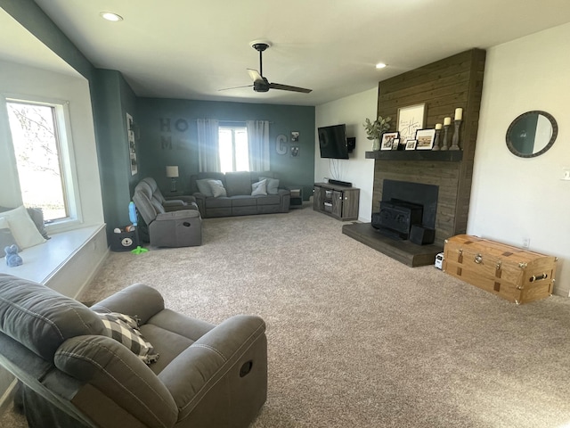 carpeted living area featuring ceiling fan, a wood stove, and recessed lighting