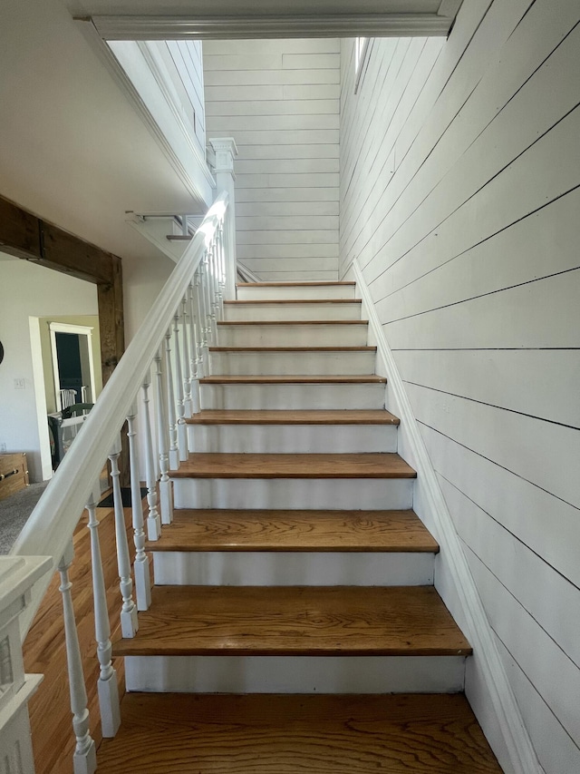 stairway featuring wooden walls and wood finished floors