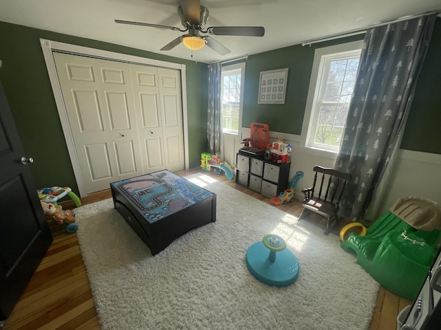 recreation room with a ceiling fan and wood finished floors