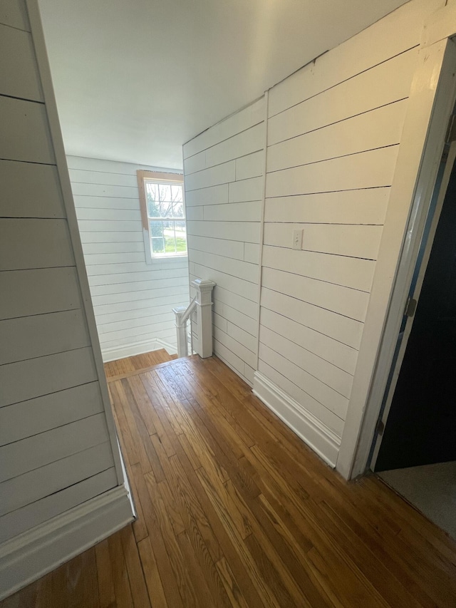 interior space featuring wood-type flooring and wood walls