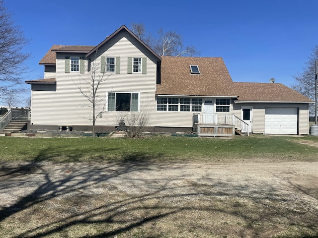 rear view of property with an attached garage, roof with shingles, and driveway