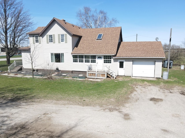 rear view of house featuring a shingled roof, an attached garage, dirt driveway, and a lawn