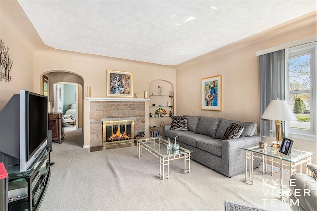 2139 Anderson Dr SE, Grand Rapids, MI 49506 - carpeted living room with a fireplace with flush hearth, arched walkways, and a textured ceiling