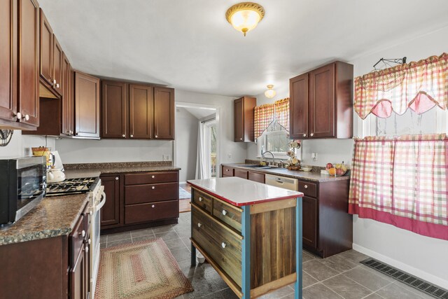 18125 174th Ave, Spring Lake, MI 49456 - kitchen with dark countertops, a sink, dark tile patterned flooring, white appliances, and visible vents