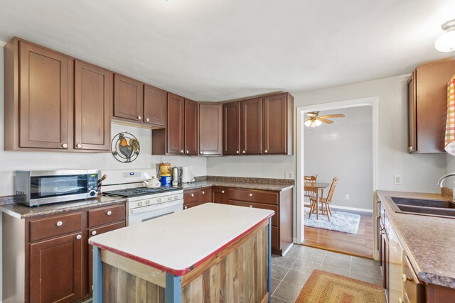 18125 174th Ave, Spring Lake, MI 49456 - kitchen with a sink, gas range gas stove, stainless steel microwave, ceiling fan, and a kitchen island