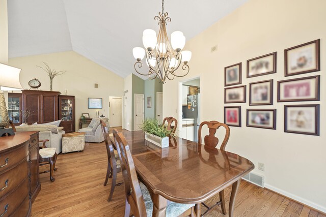 2448 Shoreham Highlands Dr, Saint Joseph, MI 49085 - dining area with a notable chandelier, visible vents, light wood-type flooring, and high vaulted ceiling