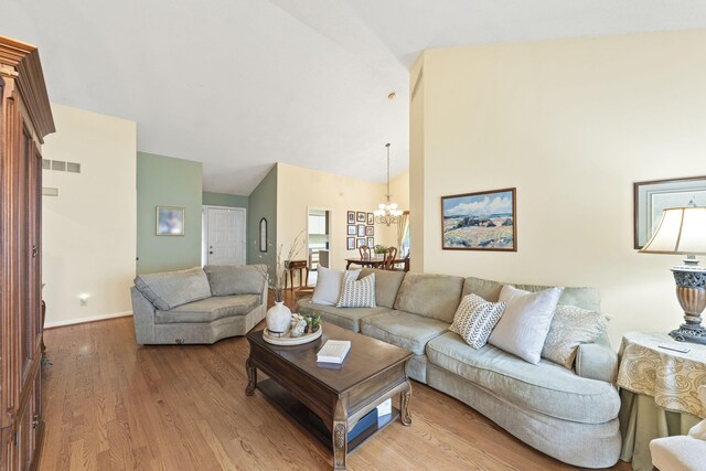 2448 Shoreham Highlands Dr, Saint Joseph, MI 49085 - living room with wood finished floors, high vaulted ceiling, visible vents, a chandelier, and baseboards