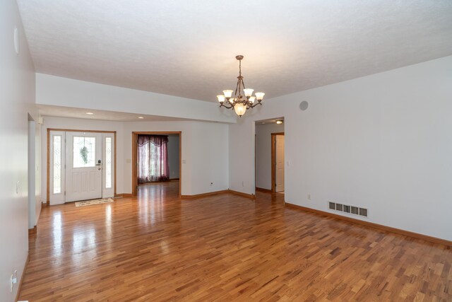 1060 Briarwood Ct, Norton Shores, MI 49441 - interior space with light wood finished floors, baseboards, visible vents, and a notable chandelier