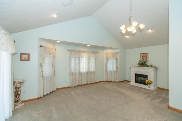 1060 Briarwood Ct, Norton Shores, MI 49441 - unfurnished living room with carpet, baseboards, a glass covered fireplace, high vaulted ceiling, and a notable chandelier
