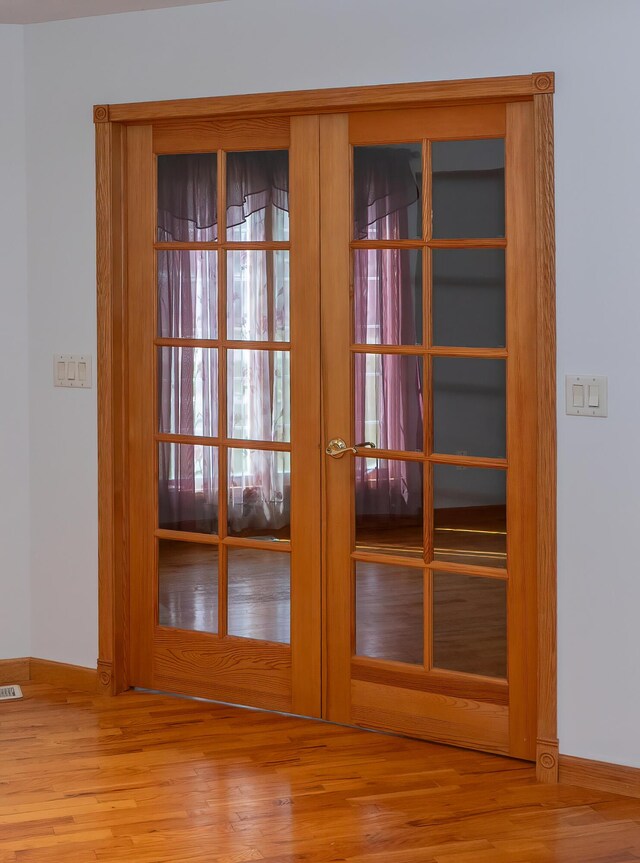 1060 Briarwood Ct, Norton Shores, MI 49441 - doorway with baseboards, french doors, wood finished floors, and visible vents