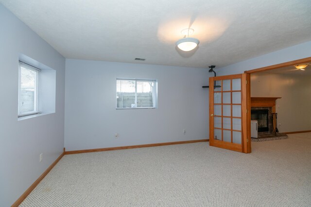 1060 Briarwood Ct, Norton Shores, MI 49441 - empty room with a fireplace, carpet floors, a healthy amount of sunlight, and visible vents