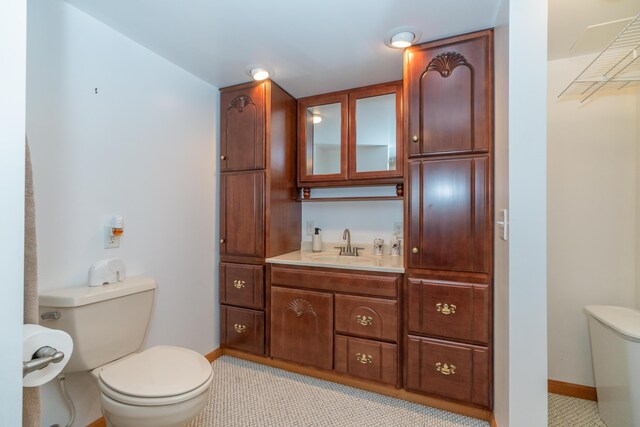 1060 Briarwood Ct, Norton Shores, MI 49441 - bathroom with vanity, toilet, and baseboards