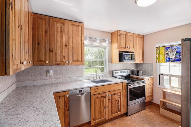 3175 Kalmbach Rd, Grass Lake, MI 49240 - kitchen featuring appliances with stainless steel finishes, a sink, tasteful backsplash, light stone counters, and brown cabinets