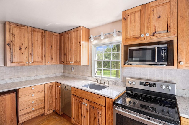 3175 Kalmbach Rd, Grass Lake, MI 49240 - kitchen featuring appliances with stainless steel finishes, a sink, backsplash, and brown cabinetry