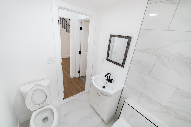21611 Conners Ave, Warren, MI 48091 - bathroom with toilet, baseboards, marble finish floor, and vanity