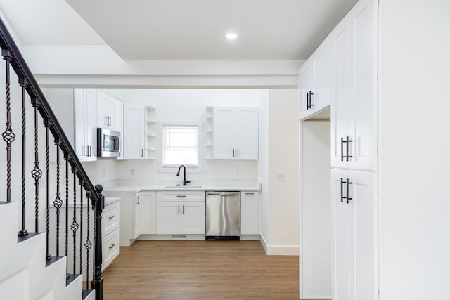 21611 Conners Ave, Warren, MI 48091 - kitchen featuring open shelves, a sink, light wood-style flooring, stainless steel appliances, and white cabinetry