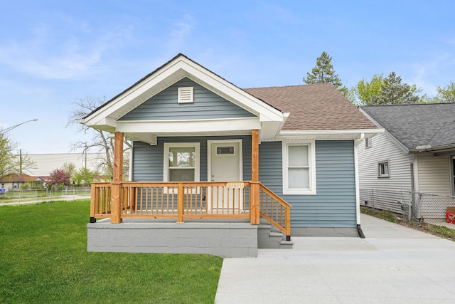 21611 Conners Ave, Warren, MI 48091 - view of front facade with a porch, roof with shingles, fence, and a front yard