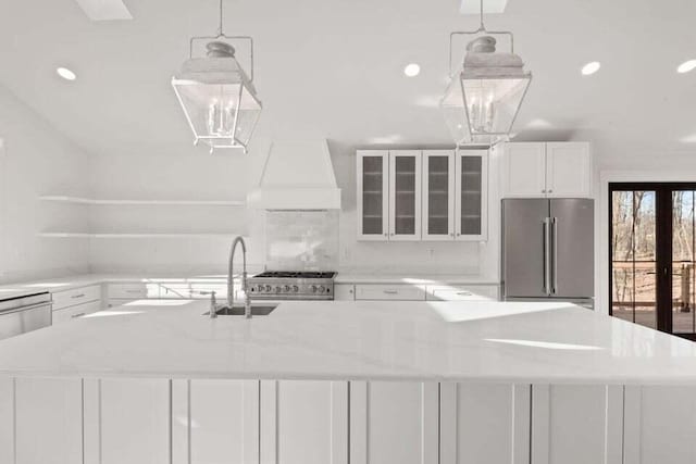 kitchen with recessed lighting, stainless steel appliances, a sink, white cabinetry, and custom range hood