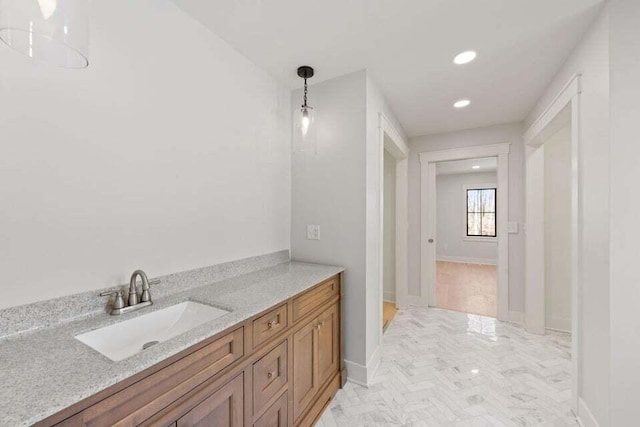 bathroom with marble finish floor, baseboards, vanity, and recessed lighting