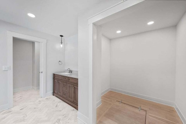 bathroom featuring baseboards, vanity, and recessed lighting