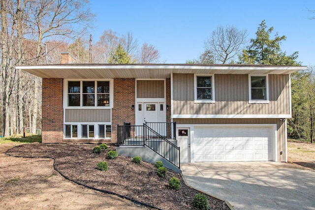 split foyer home featuring driveway, brick siding, and an attached garage