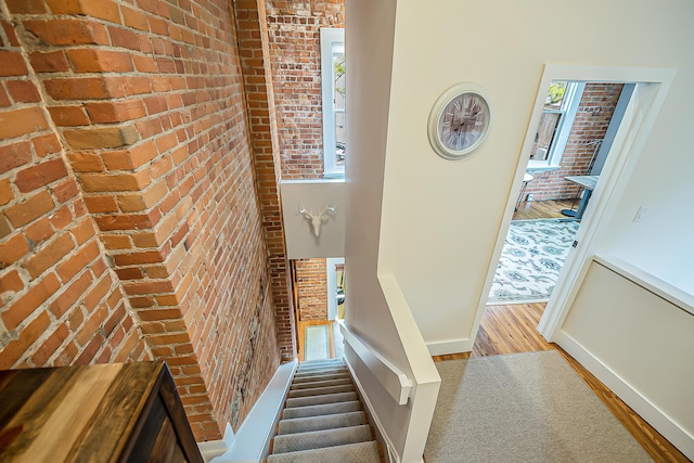 113 S Fourth Ave Unit 6, Ann Arbor, MI 48104 - stairway featuring brick wall, wood finished floors, and baseboards