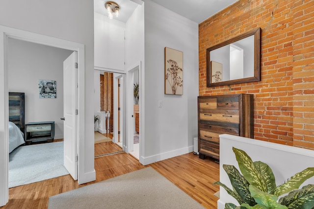 113 S Fourth Ave Unit 6, Ann Arbor, MI 48104 - hall with light wood-style floors, baseboards, and brick wall