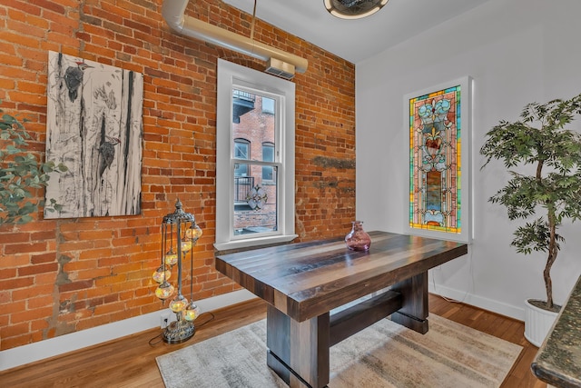 113 S Fourth Ave Unit 6, Ann Arbor, MI 48104 - dining area with baseboards, wood finished floors, and brick wall
