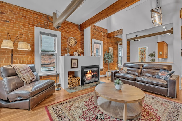 113 S Fourth Ave Unit 6, Ann Arbor, MI 48104 - living room with brick wall, plenty of natural light, wood finished floors, a multi sided fireplace, and beam ceiling
