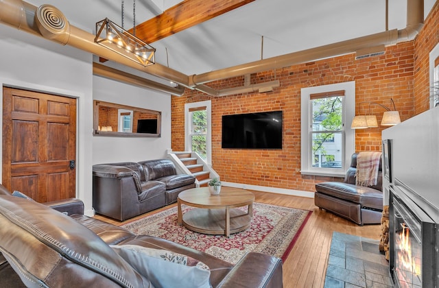 113 S Fourth Ave Unit 6, Ann Arbor, MI 48104 - living area with beam ceiling, hardwood / wood-style flooring, brick wall, and baseboards