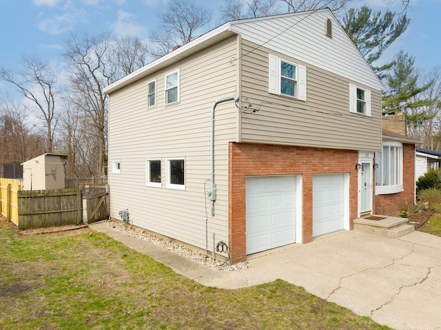 view of side of home with driveway, a chimney, fence, a garage, and brick siding