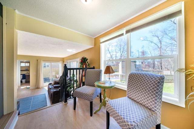 living area featuring ornamental molding and wood finished floors