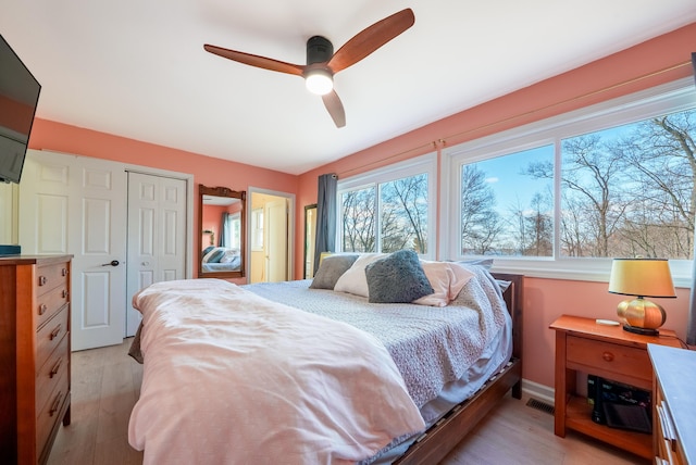 bedroom featuring ceiling fan, light wood-style floors, and visible vents