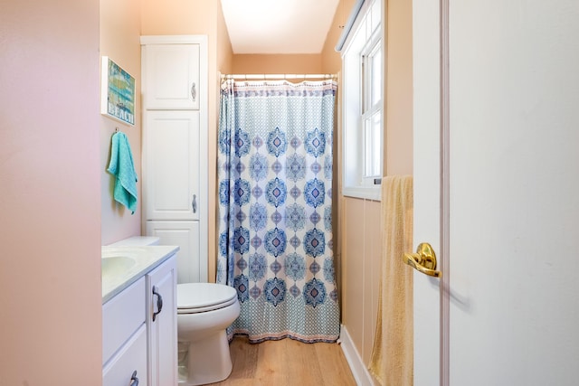 full bath with curtained shower, wood finished floors, toilet, and vanity