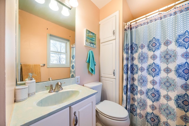 bathroom featuring toilet, vanity, and curtained shower