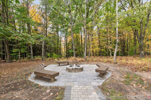 view of patio / terrace featuring a fire pit and a forest view