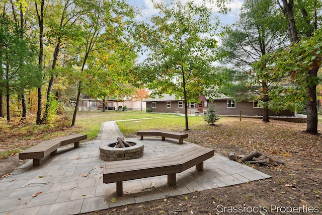 surrounding community featuring a fire pit, a patio area, and a lawn