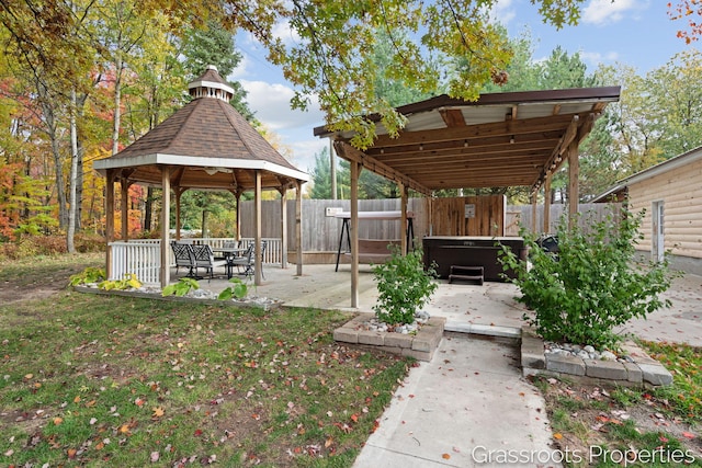 view of yard featuring a fenced backyard, a gazebo, a hot tub, and a patio