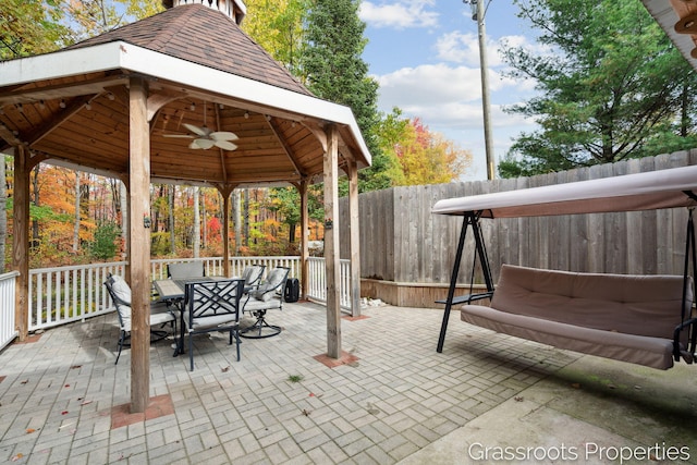 view of patio / terrace featuring a gazebo, outdoor dining space, a fenced backyard, and ceiling fan
