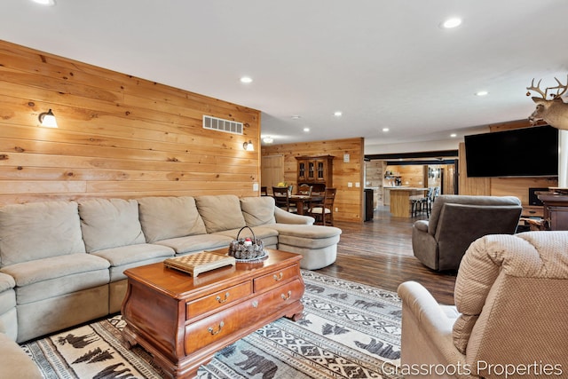 living room with visible vents, wood finished floors, wooden walls, and recessed lighting