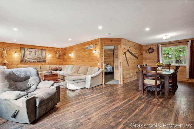 living area with dark wood finished floors, visible vents, wooden walls, and recessed lighting