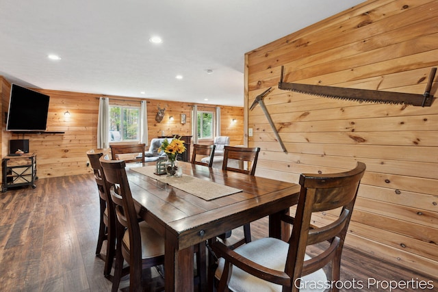 dining space featuring recessed lighting, wooden walls, and wood finished floors