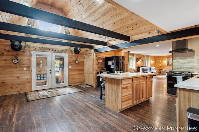 kitchen featuring wall chimney exhaust hood, a healthy amount of sunlight, double oven range, freestanding refrigerator, and dark wood-type flooring