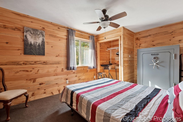 bedroom featuring carpet flooring, wood walls, and a ceiling fan