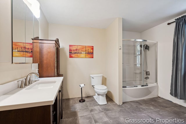full bathroom featuring toilet, vanity, and enclosed tub / shower combo