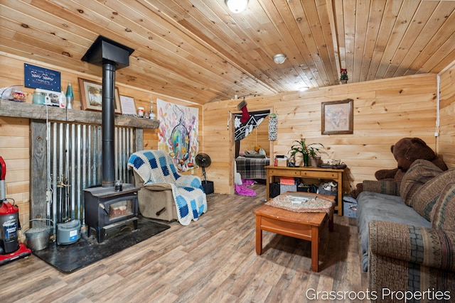 living room featuring wood walls, wood finished floors, and a wood stove