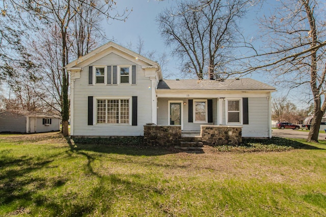 view of front facade with a storage unit, an outbuilding, a porch, and a front lawn