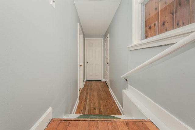 hallway featuring baseboards and wood finished floors